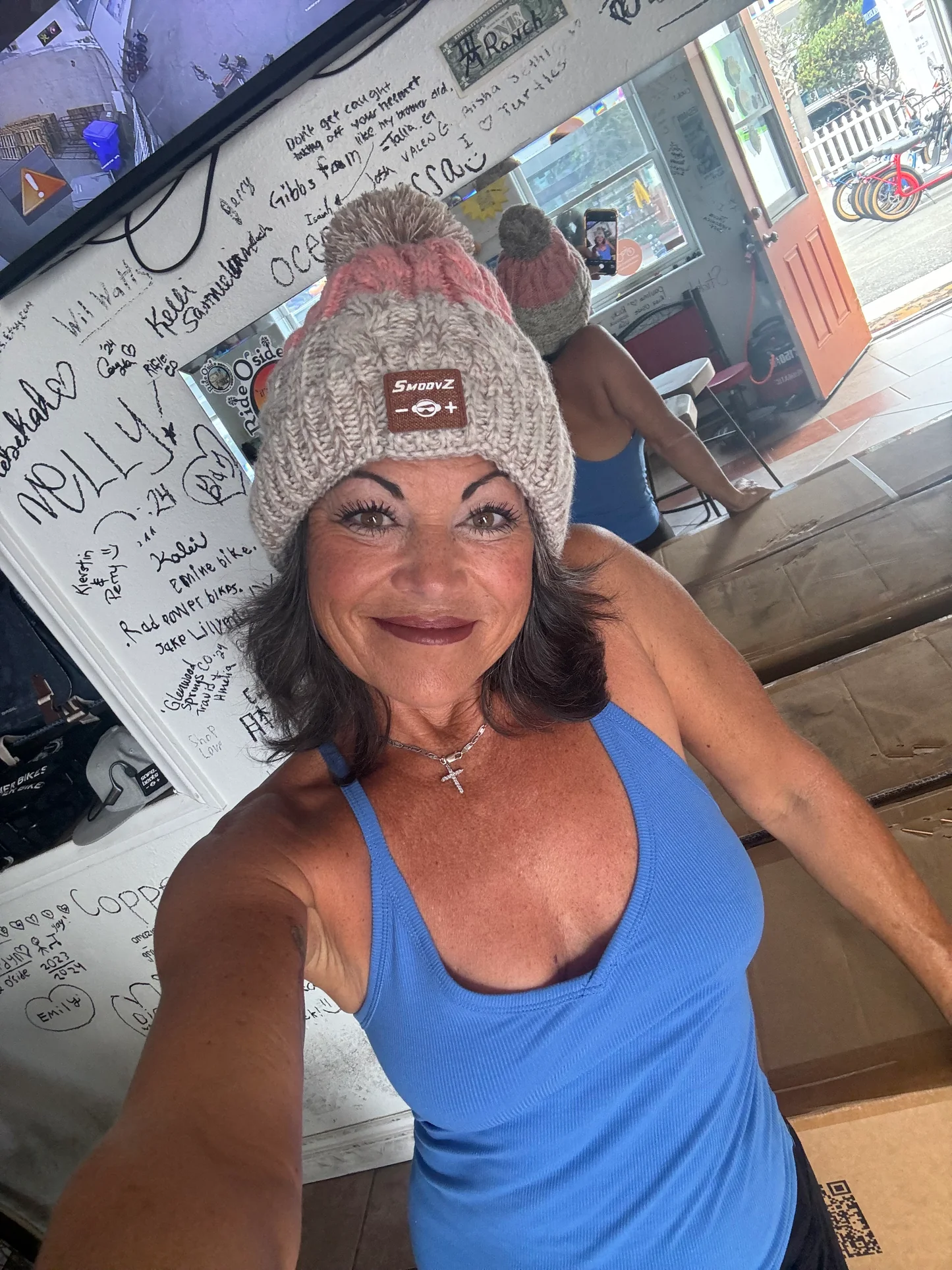 A woman is wearing open-ear beanie headphones.