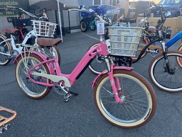 A pink electric bicycle with a basket on the front of it