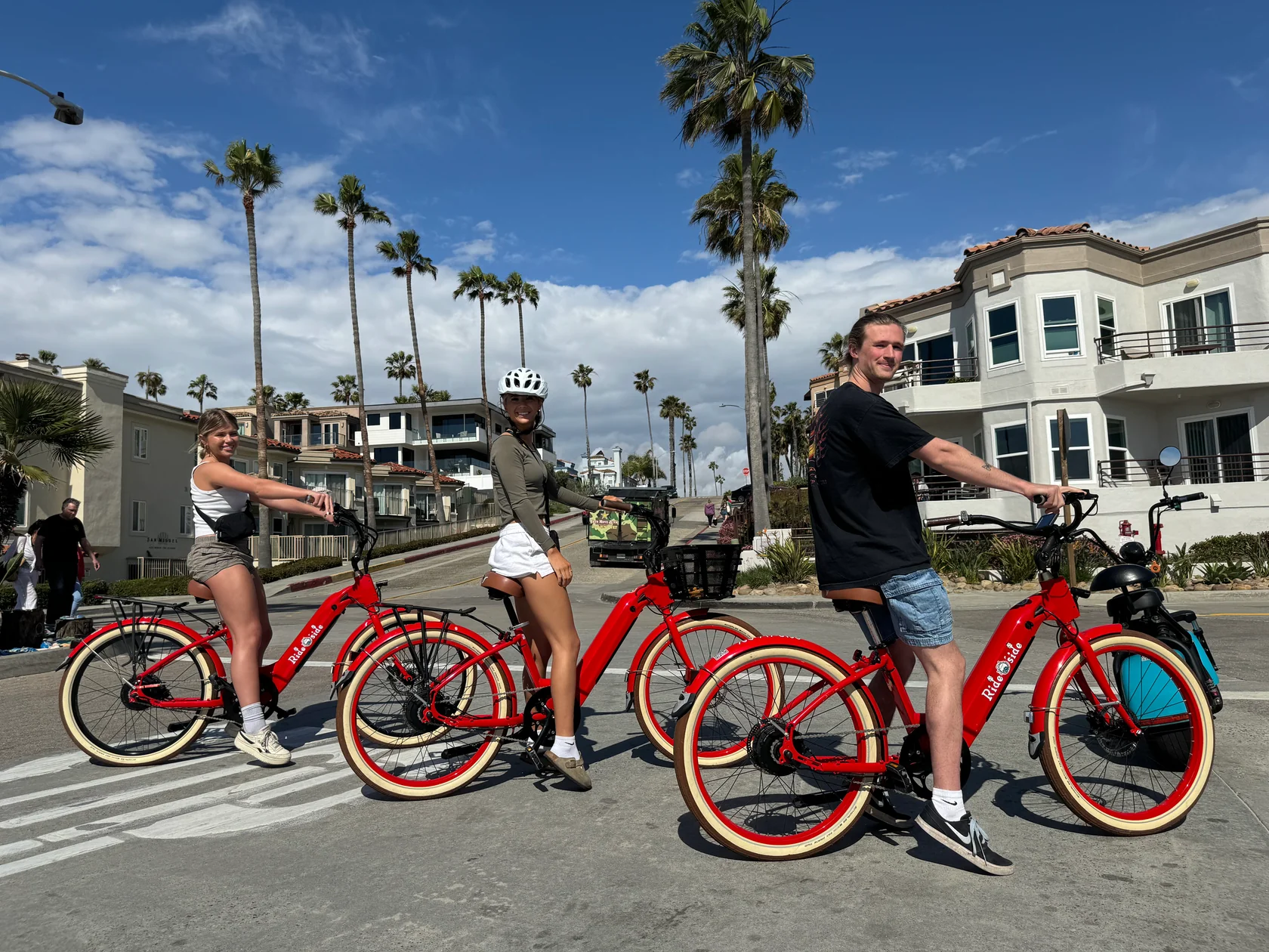 A group of people are riding electric bicycles down a street.