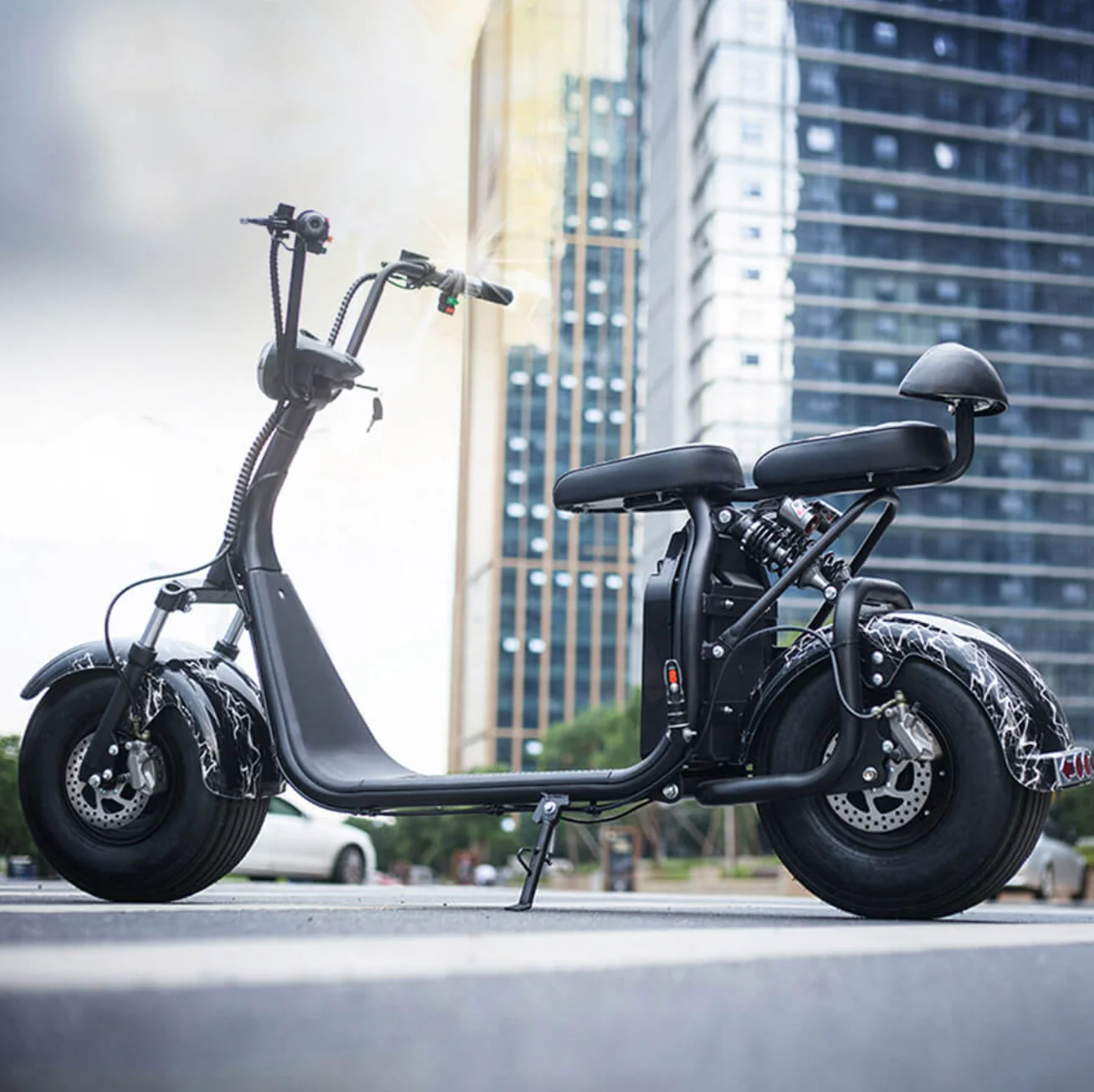 A black electric scooter is parked on the side of the road.
