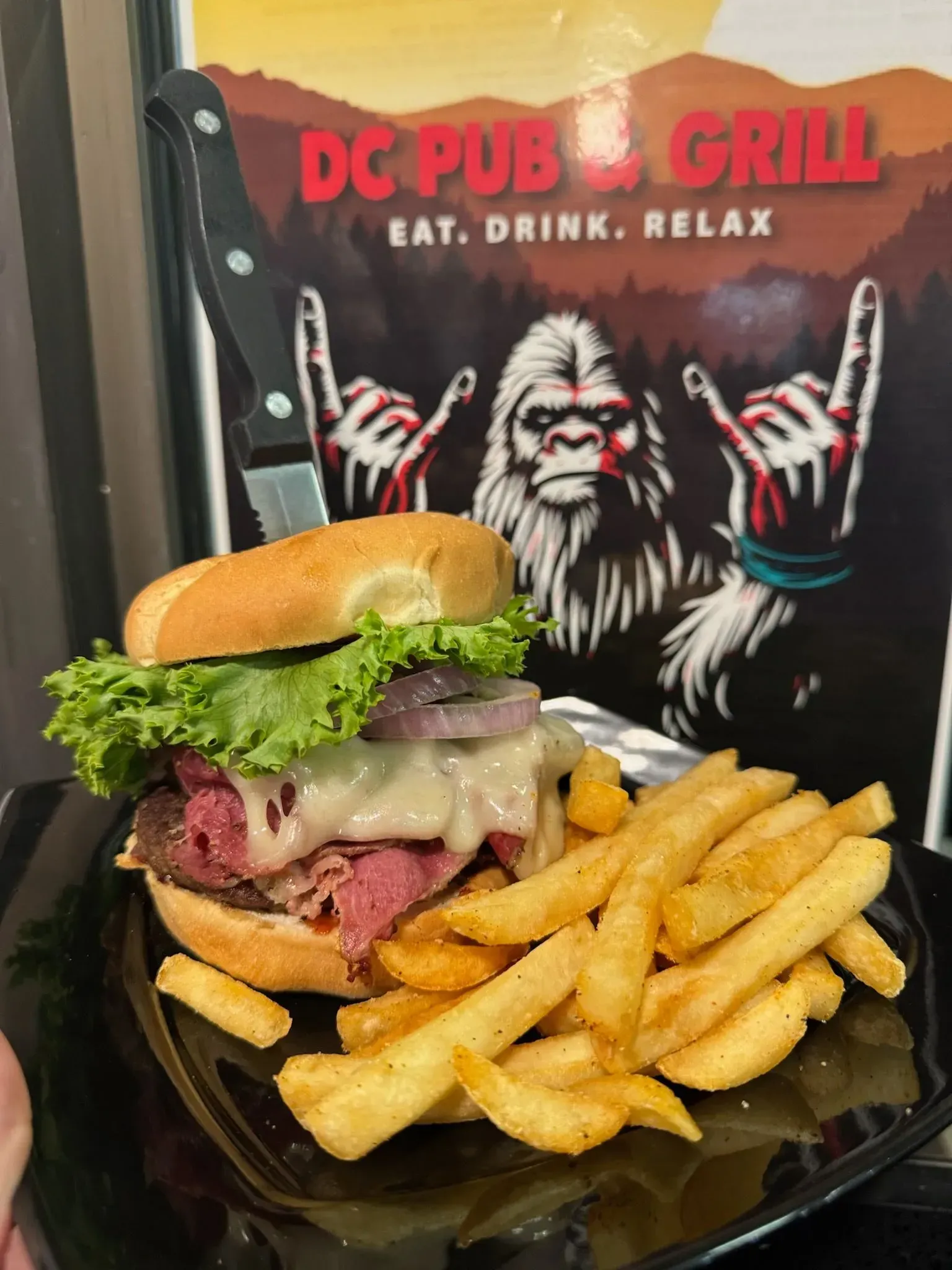 Spacious living room with a leather sectional, fireplace, large TV, and windows overlooking a balcony.
