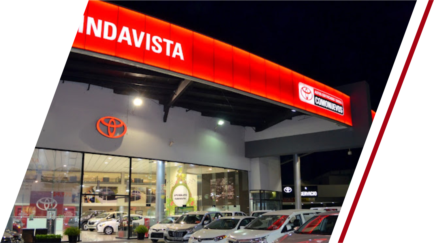 Un concesionario Toyota con muchos coches aparcados delante.