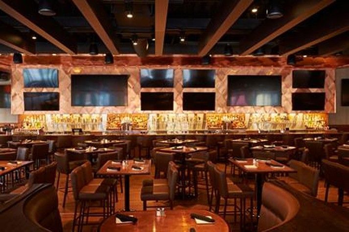 A restaurant filled with tables and chairs and a bar.