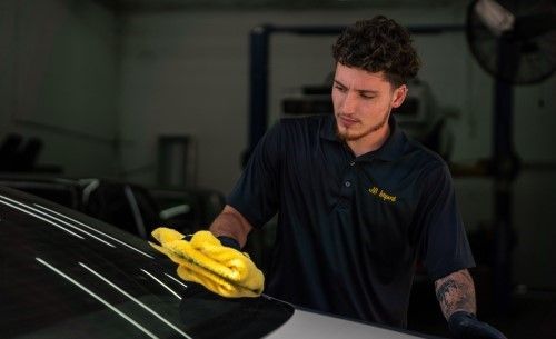 Mason cleaning the windshield of a car