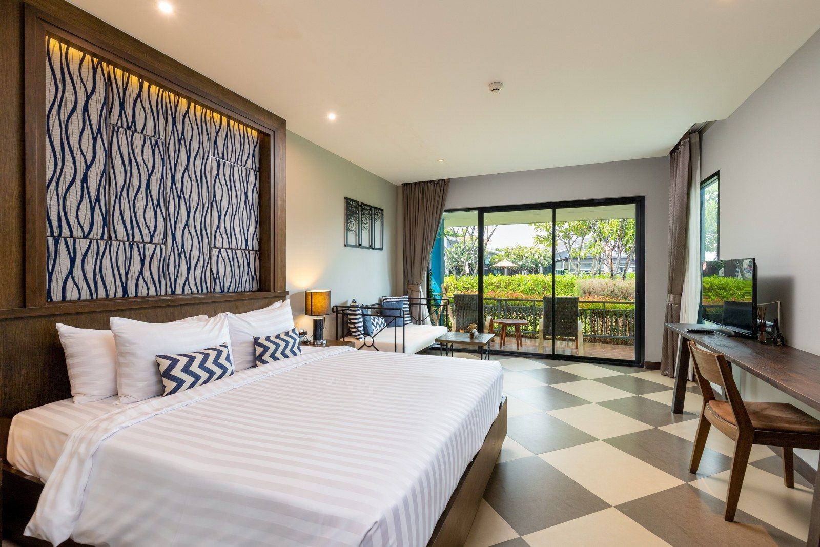 Bedroom with large bed, patterned wall, checkered floor, and balcony access.