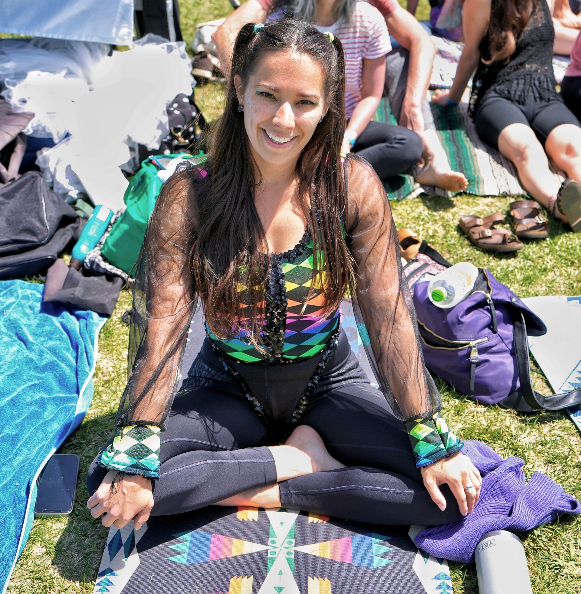 a young woman sitting smiling with butterfly attire.