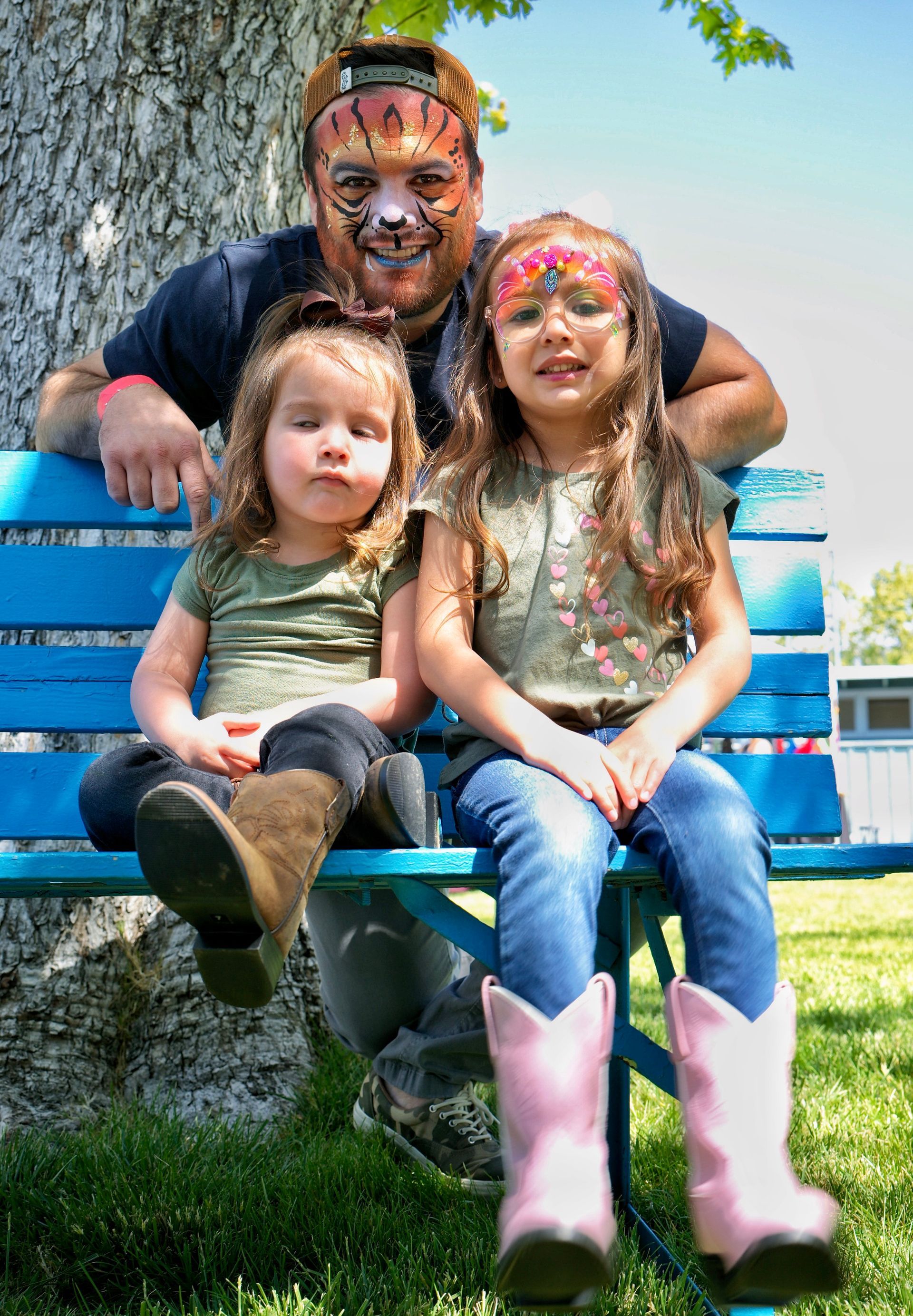 two girls sitting on a bench at the festival