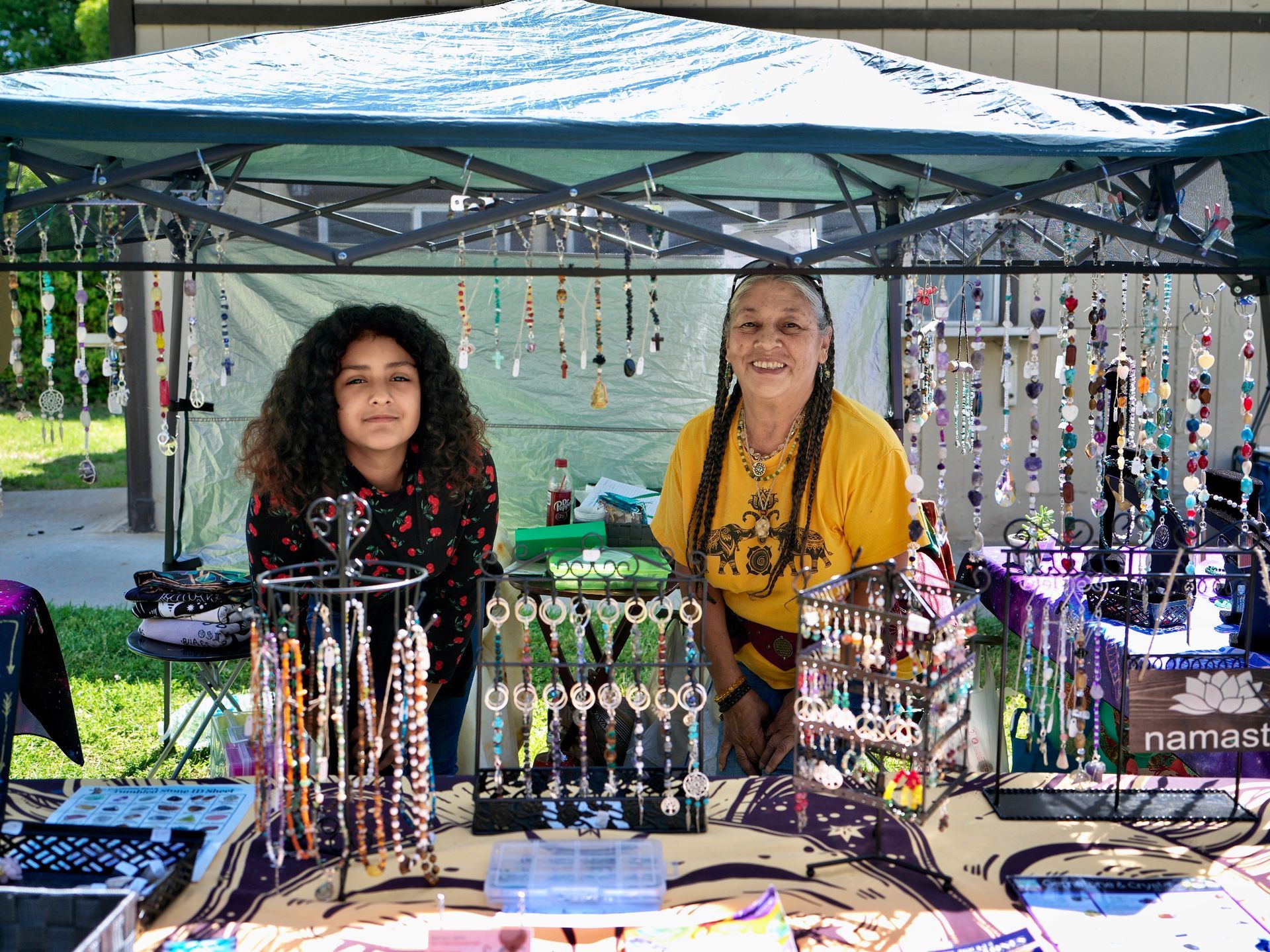 two young girls in a vendor booth with jewelry