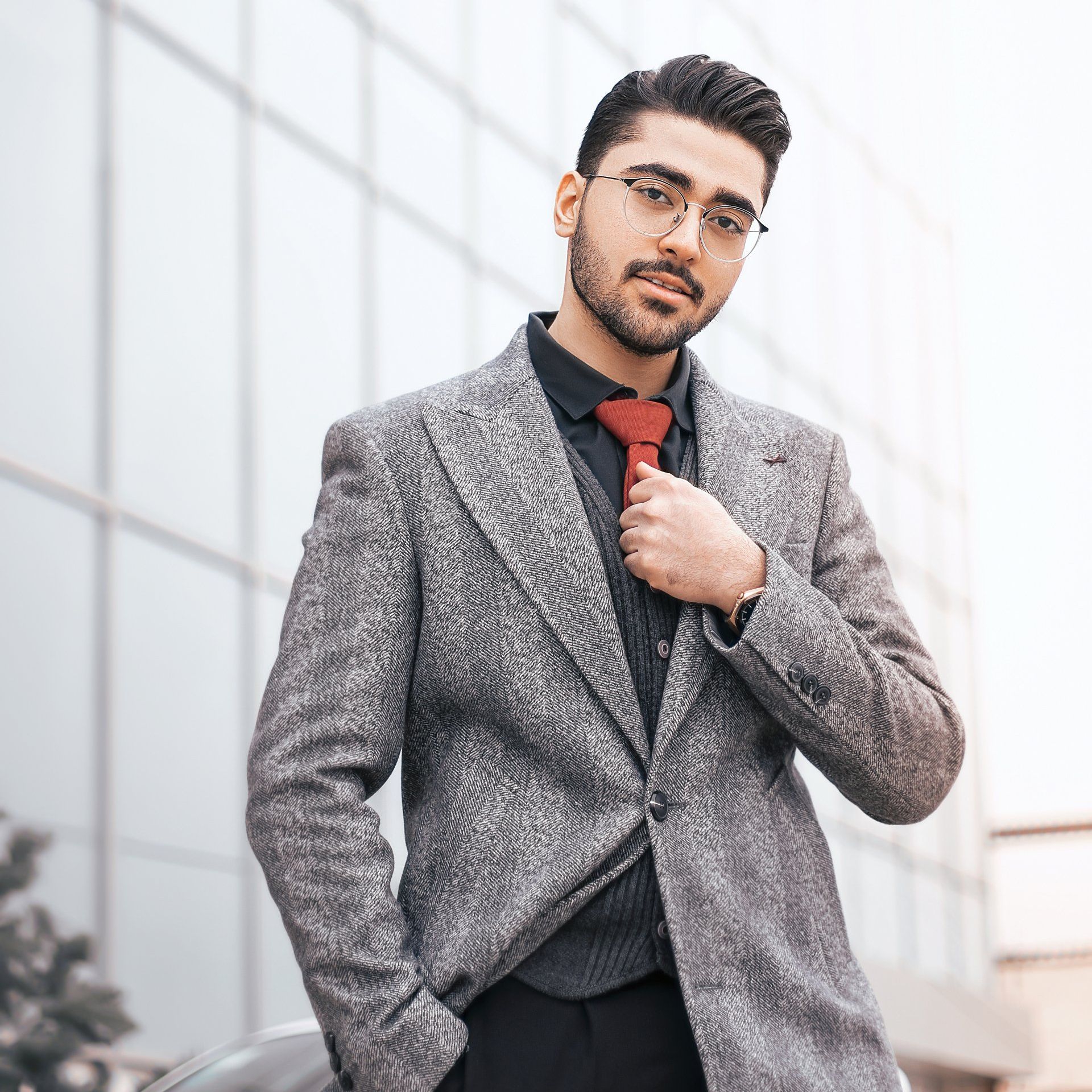 A man in a suit and tie is standing next to a car.