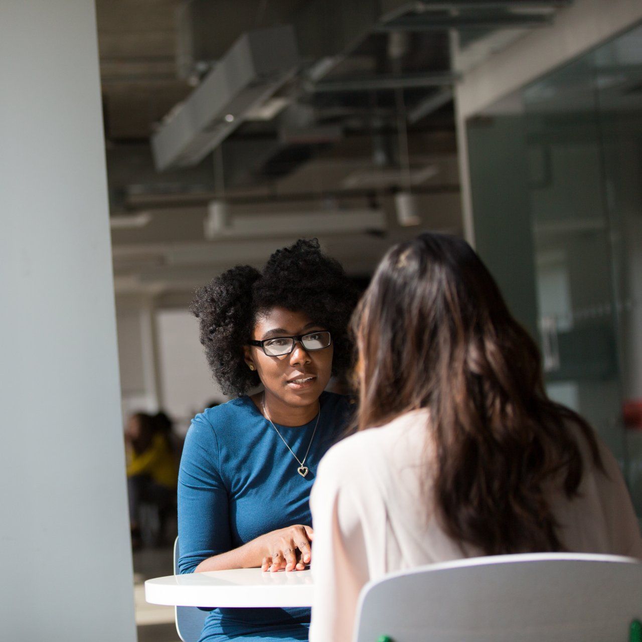 Two women are sitting at a table having a conversation
