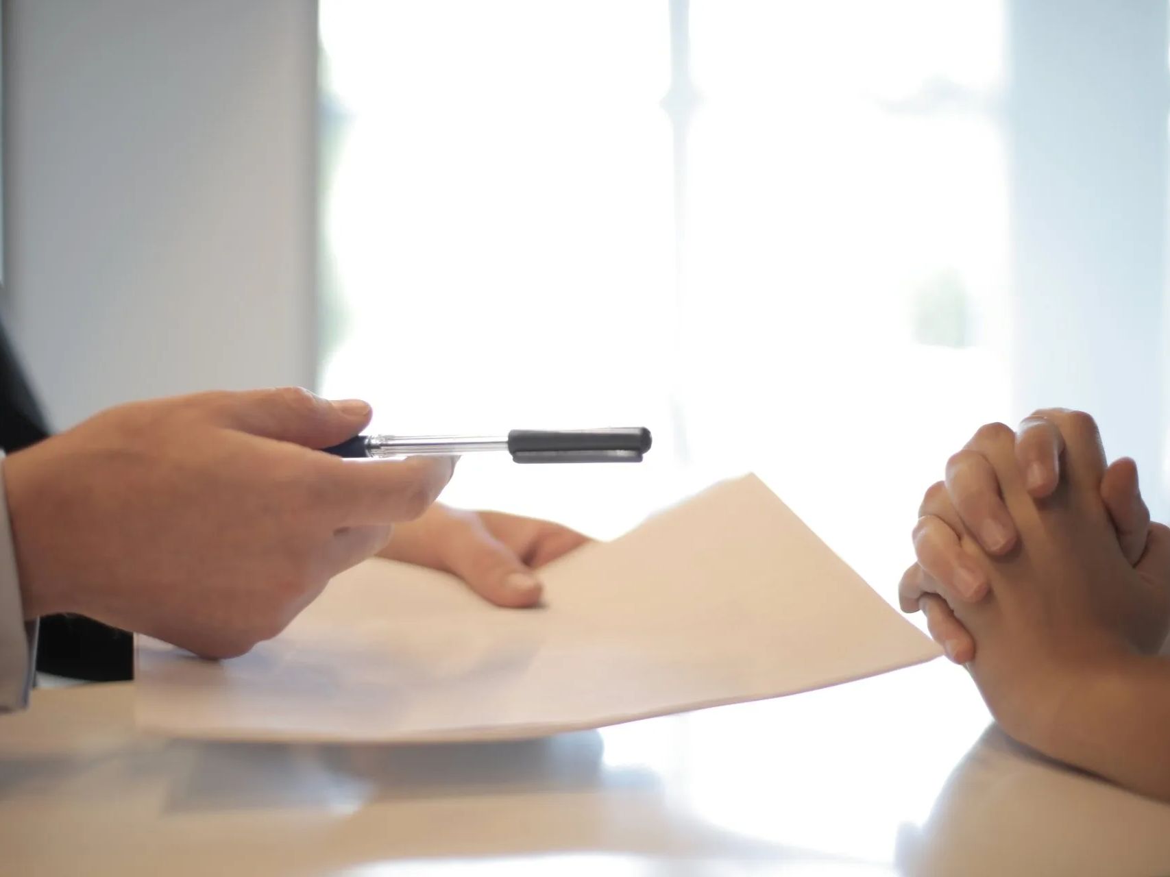 A person is holding a pen over a piece of paper