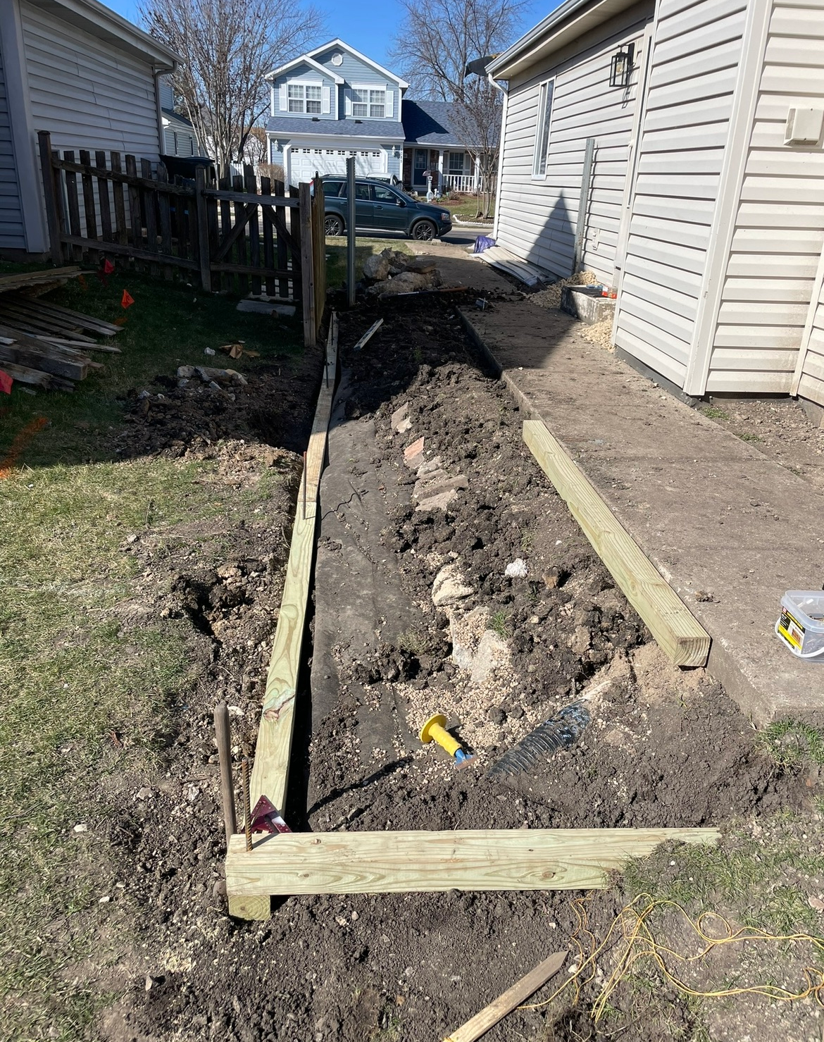 A wooden fence is being built in the backyard of a house.