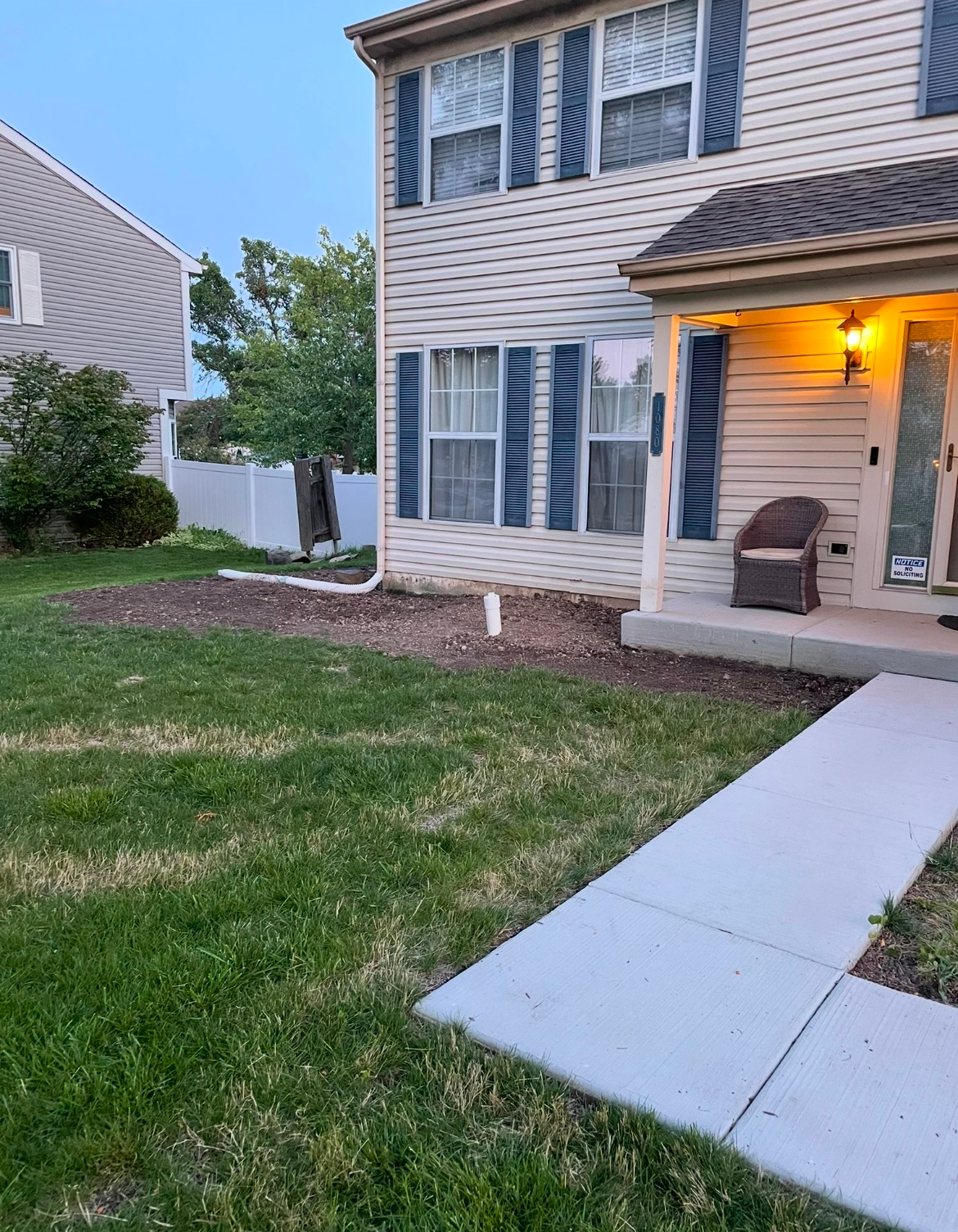 A house with a porch and a chair in front of it.