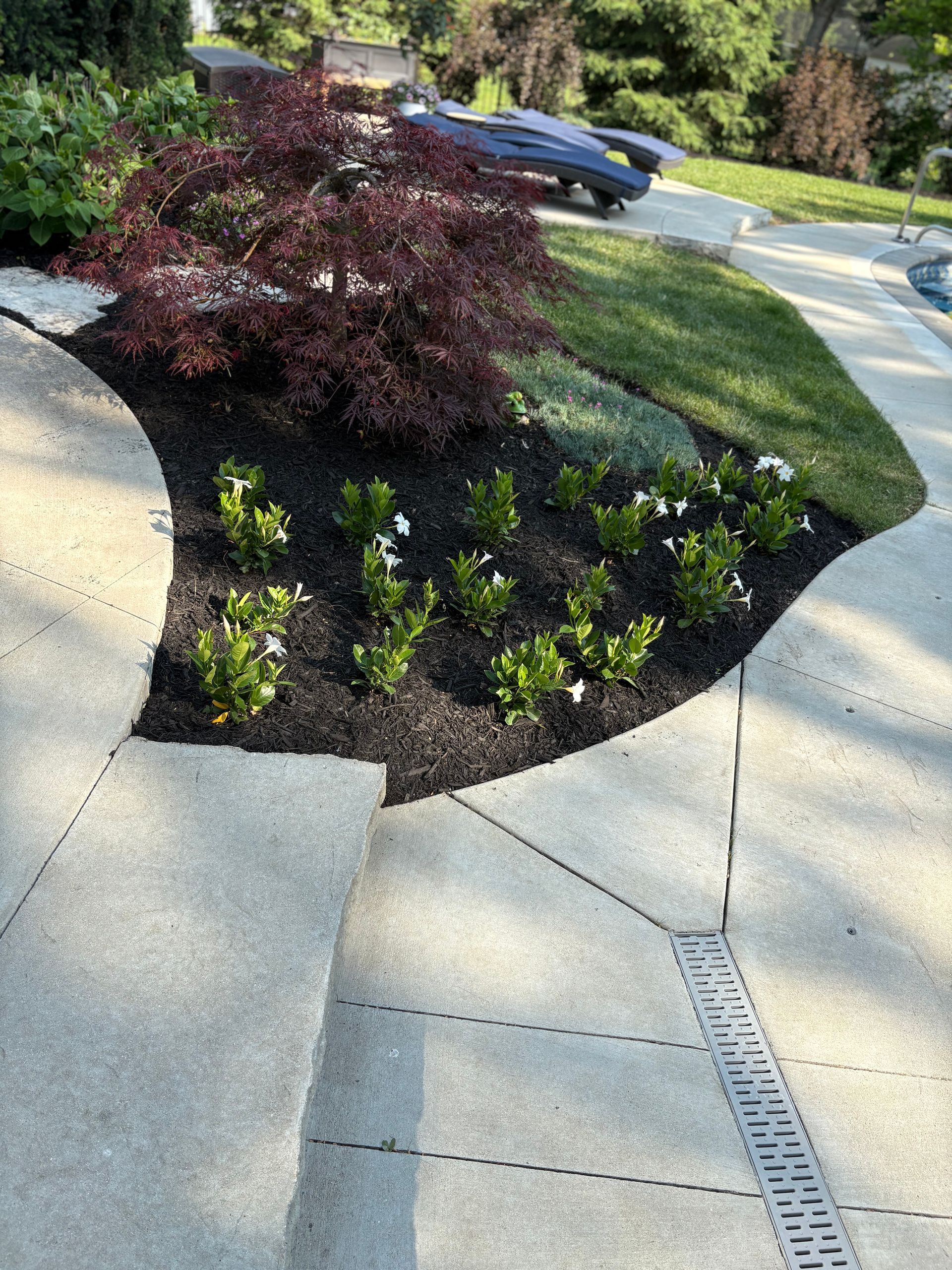 A concrete walkway with a drain in the middle of it.