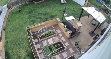 An aerial view of a backyard with a garden and patio.