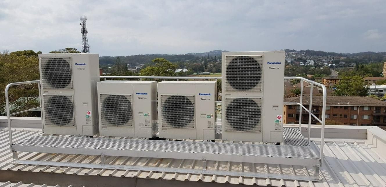 A Row of Air Conditioners Are Sitting on Top of A Roof — Gleeson's Air Conditioning in Port Macquarie, NSW
