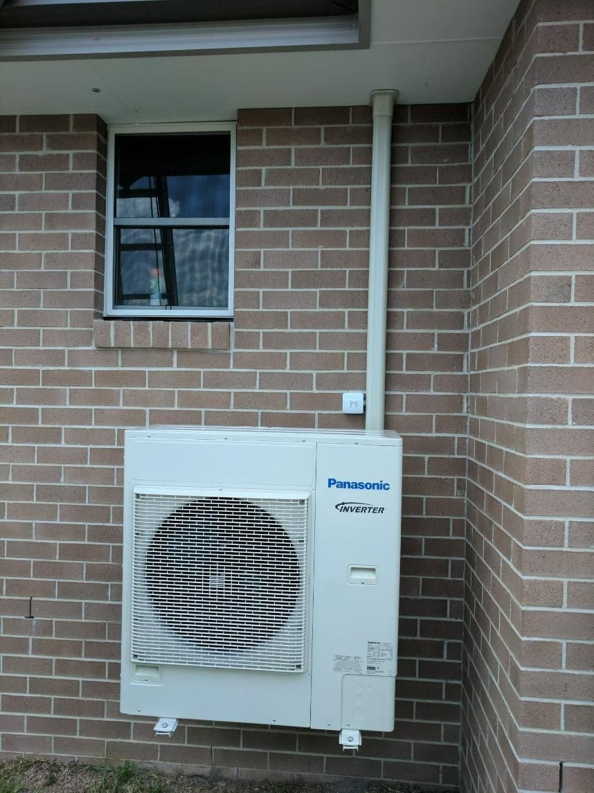 A Panasonic Air Conditioner Is Mounted on The Side of A Brick — Gleeson's Air Conditioning in Wauchope, NSW