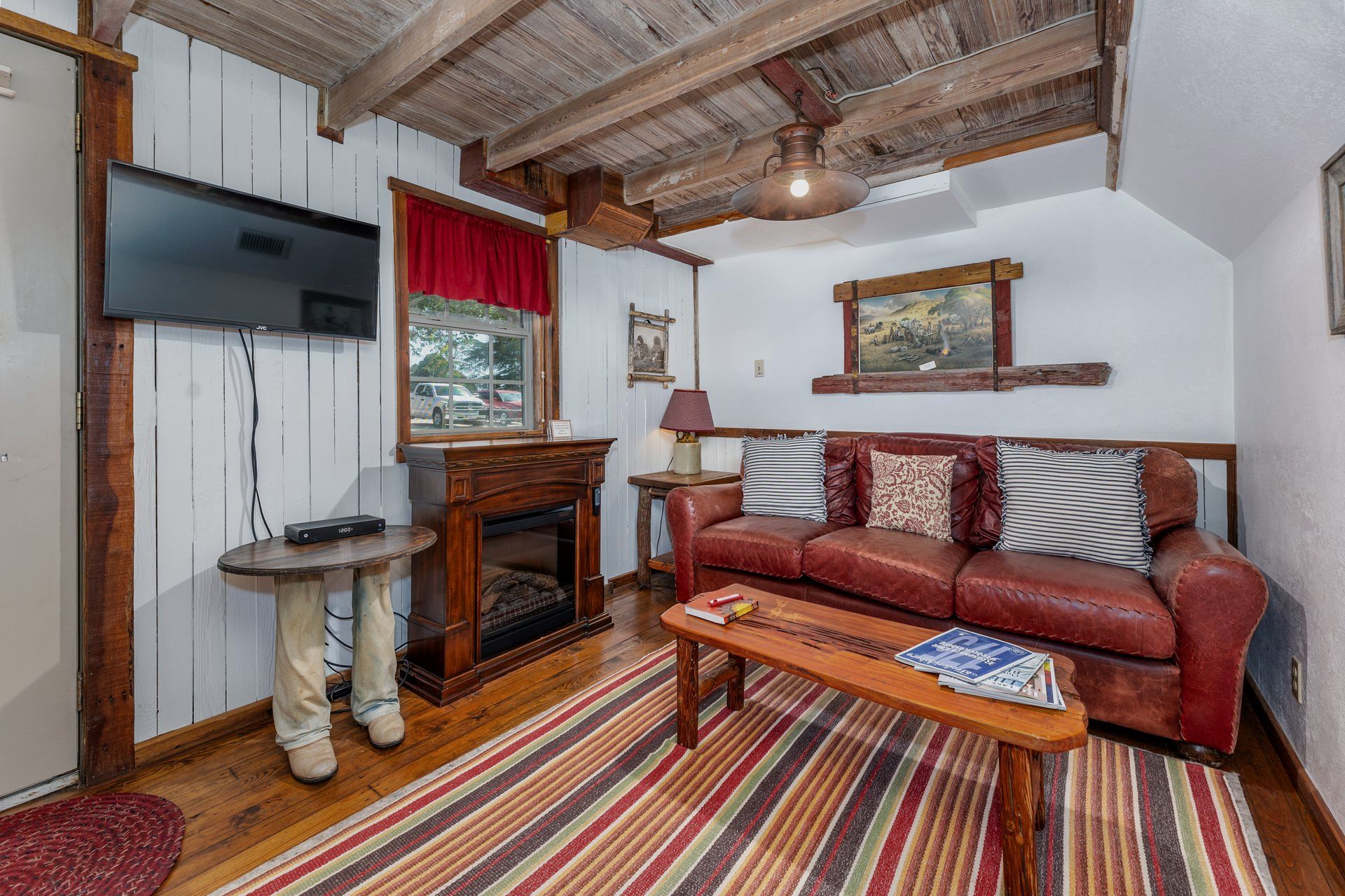 A living room with a couch , table , fireplace and television.