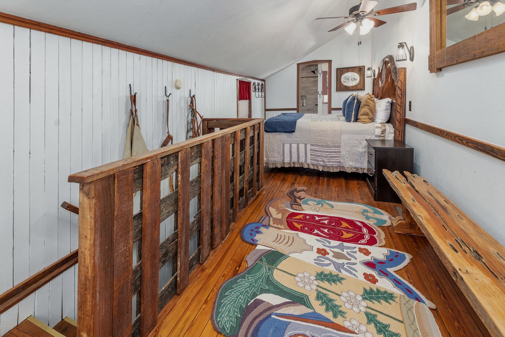 A bedroom with a bed and a rug on the floor.