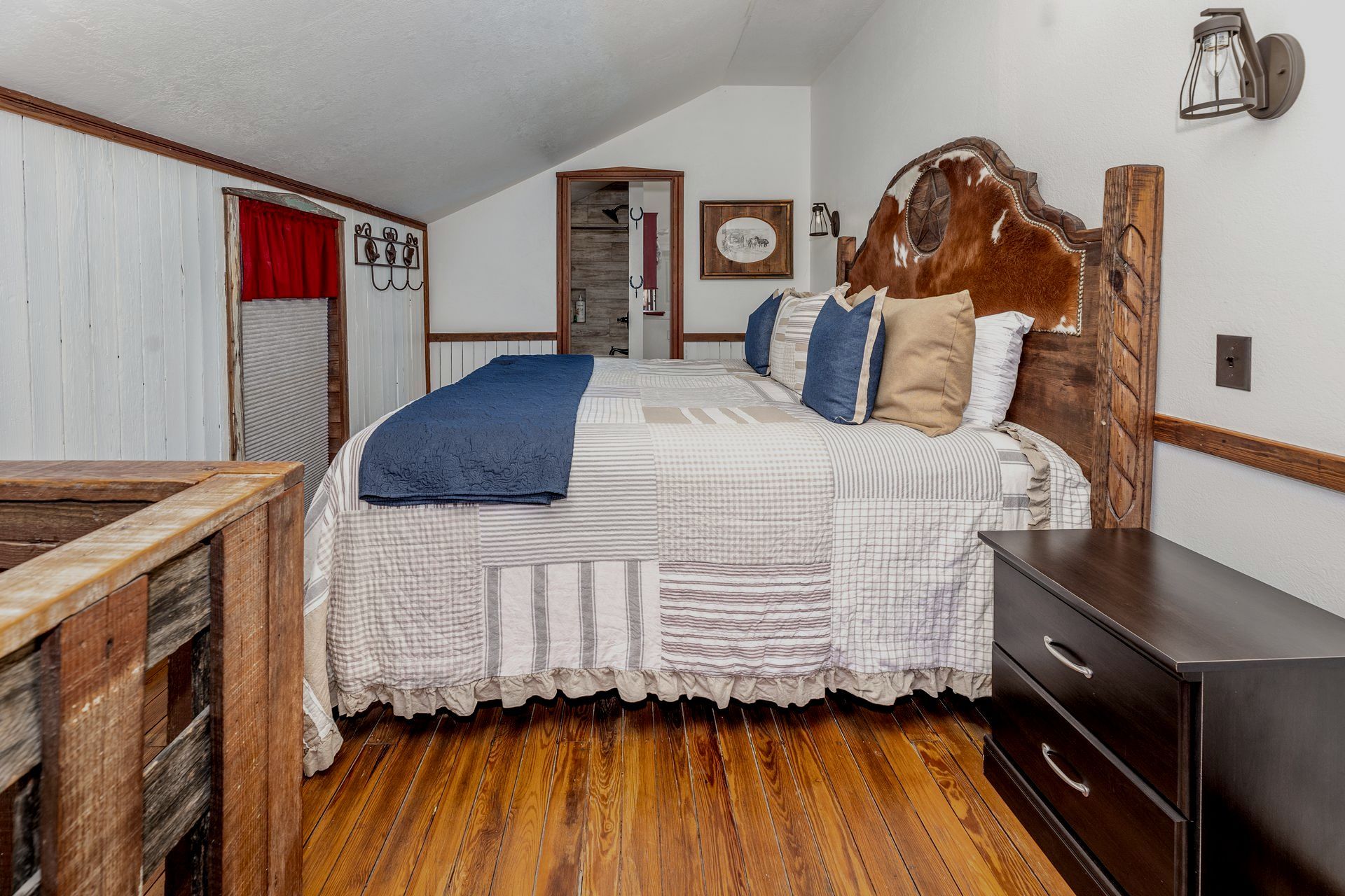 A bedroom with a king size bed and a dresser.