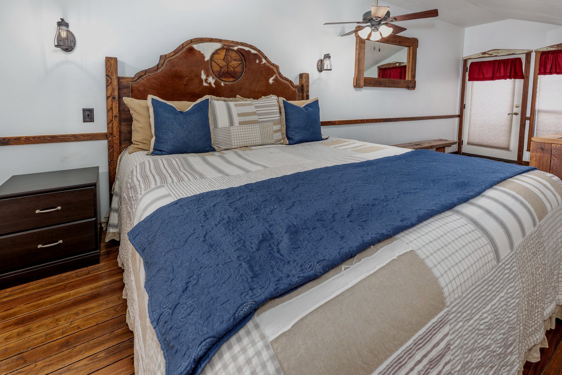 A bedroom with a king size bed and a ceiling fan.