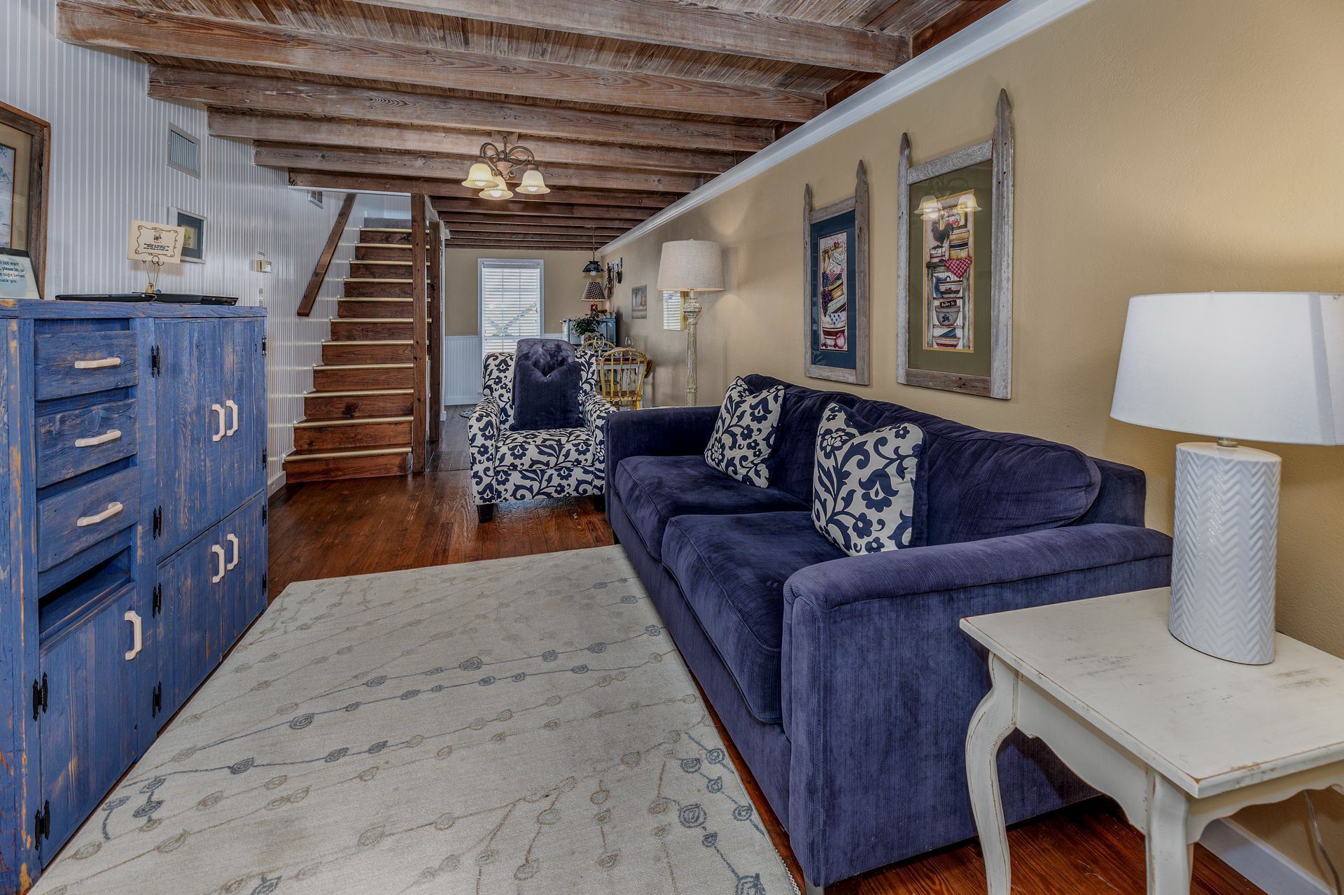 A living room with a blue couch and chairs