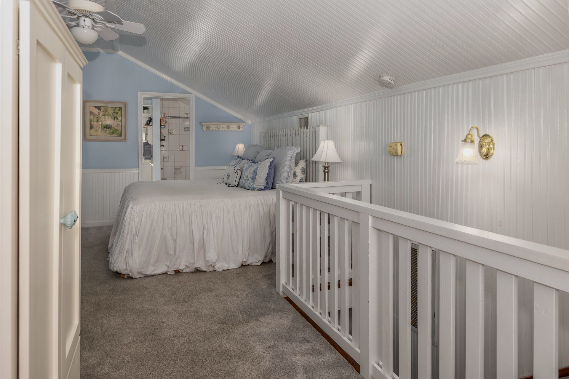 A bedroom with a bed and a staircase leading to it.