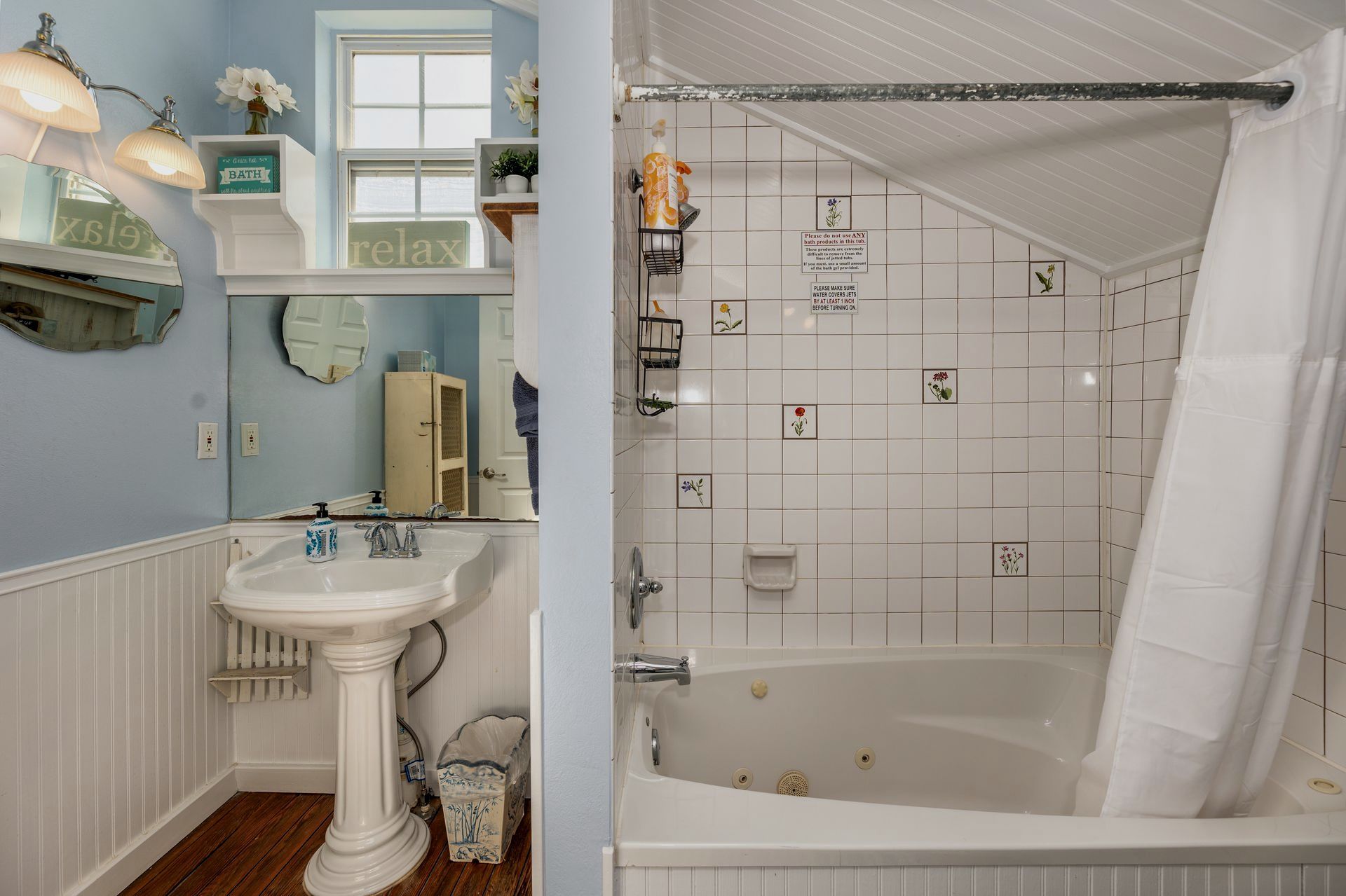 A bathroom with a sink , tub , shower and mirror.