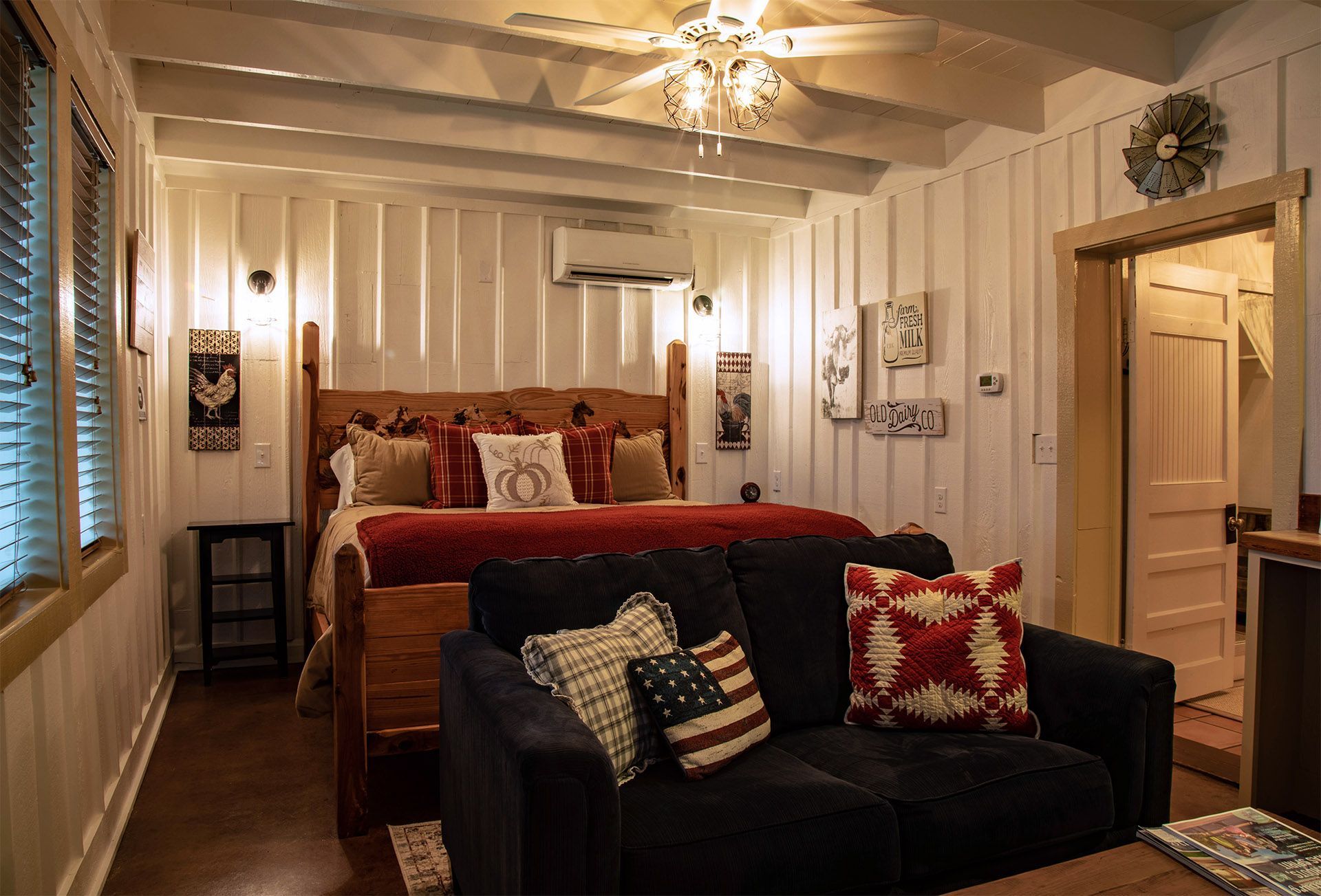 A bedroom with a couch , bed , and ceiling fan.
