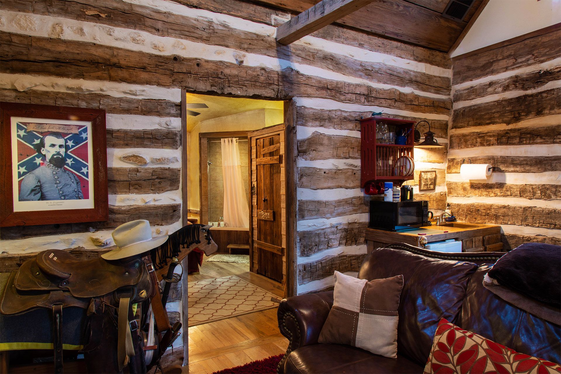 A living room in a log cabin with a couch and a picture on the wall.