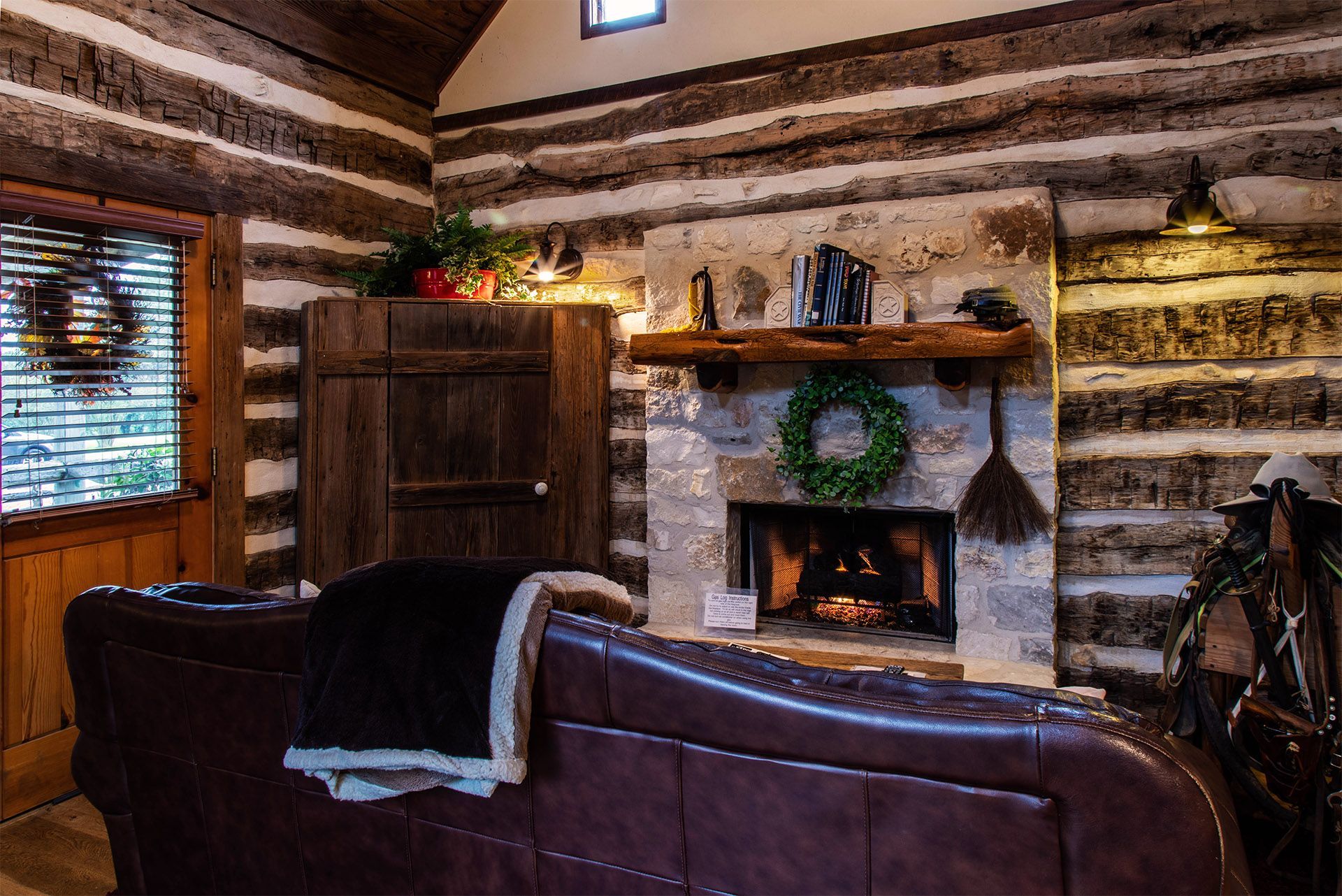 A living room in a log cabin with a fireplace and a couch.