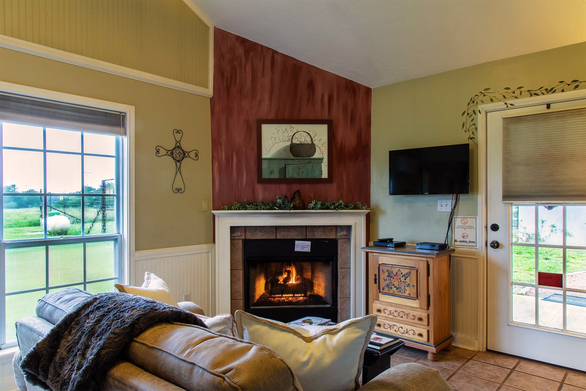 A living room with a fireplace , couch , and television.