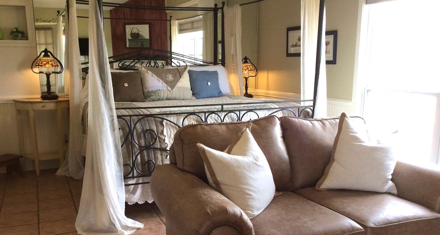 A living room with a couch and a canopy bed