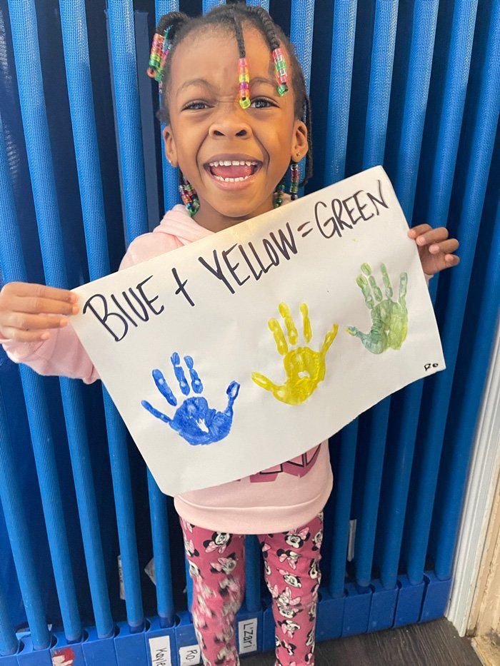 Happy Kid Holding Her Artwork — Knoxville, TN — Marcia’s Learning Center