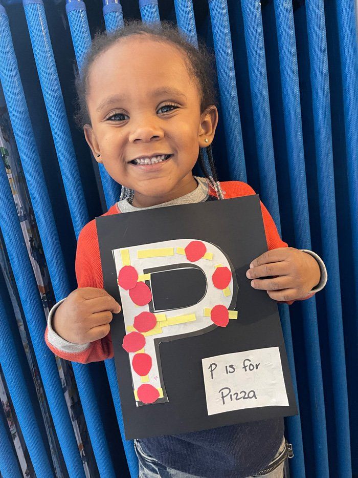 Little Girl Holding Her Artwork — Knoxville, TN — Marcia’s Learning Center