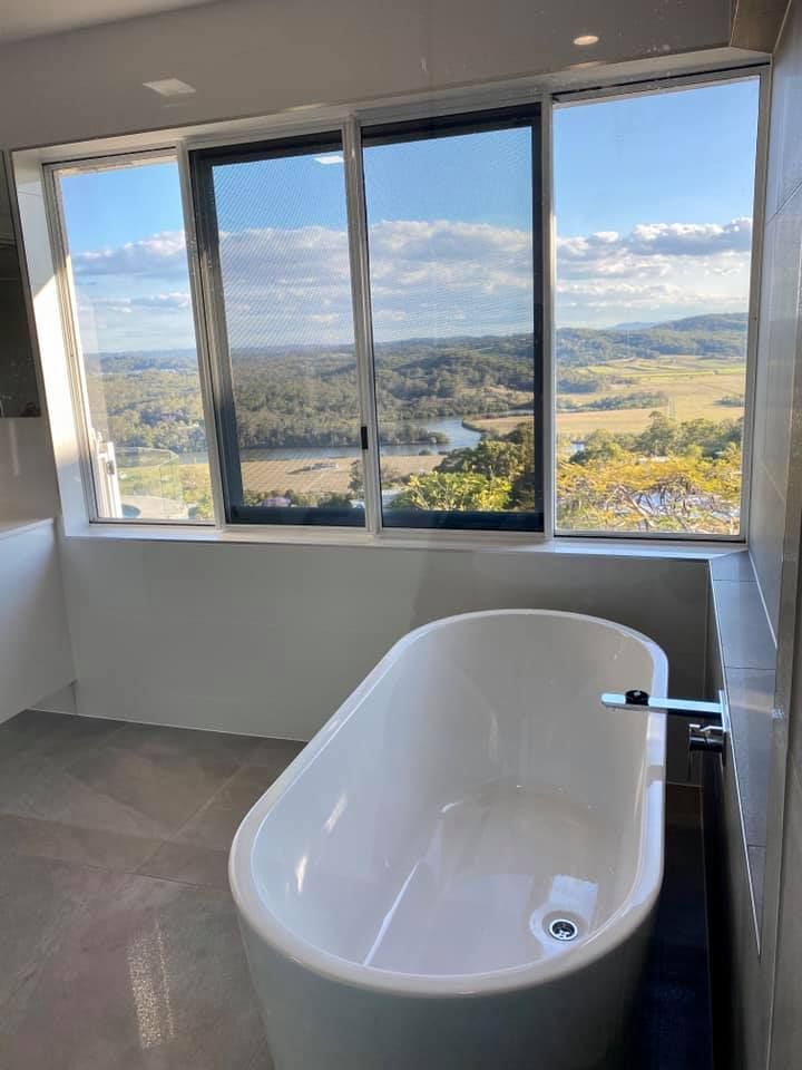 A Bathroom With a Bathtub and a Large Window — NGK Constructions In Freshwater, QLD