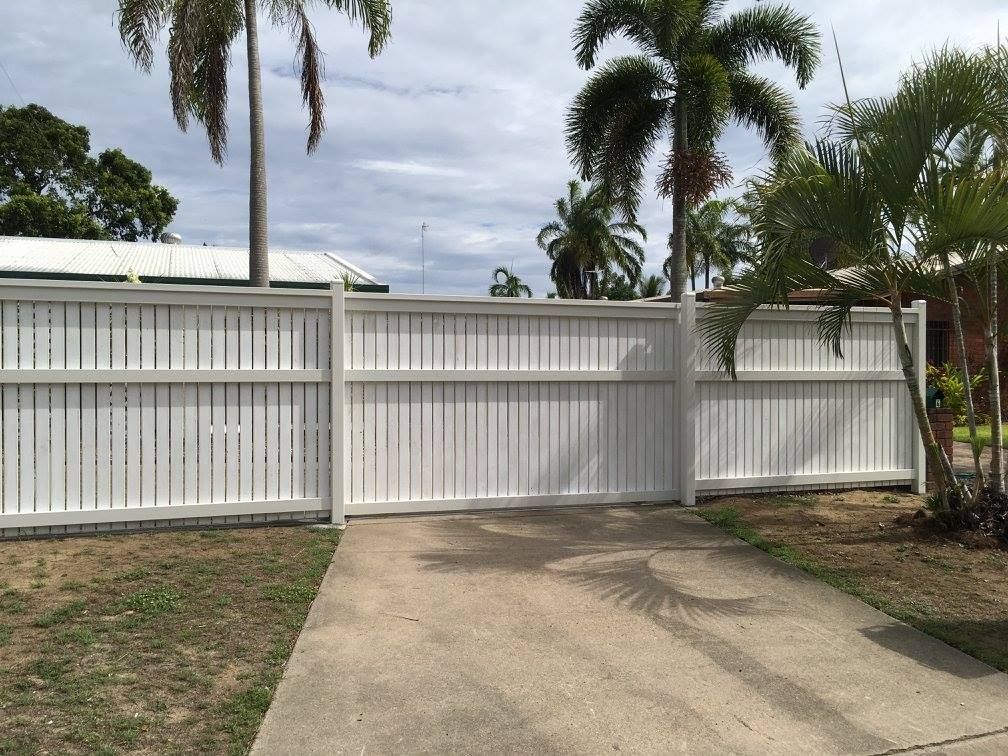 A White Fence Surrounds a Driveway With Palm Trees in the Background — NGK Constructions In Freshwater, QLD