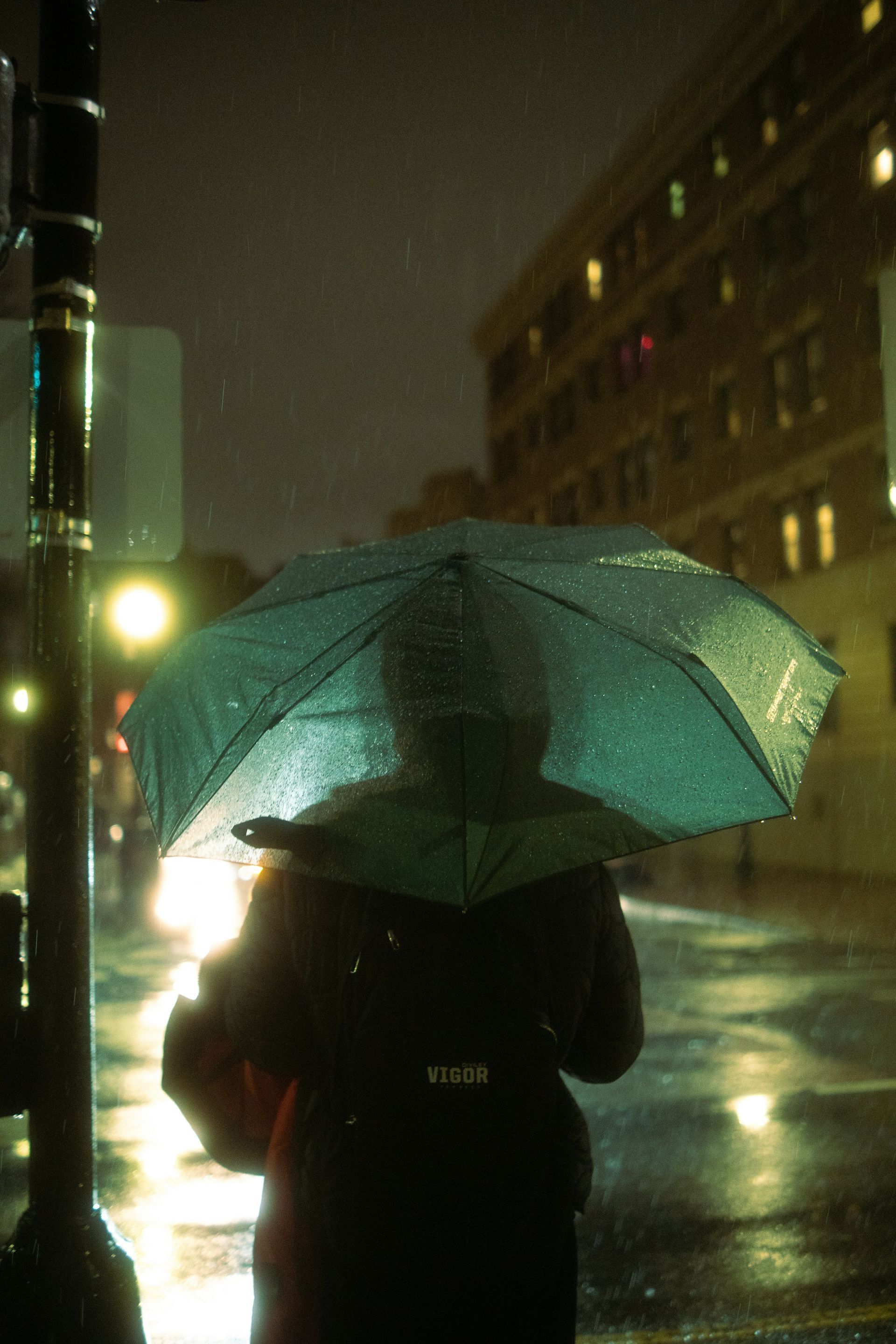 Two men in red shirts and helmets are climbing a wall.
