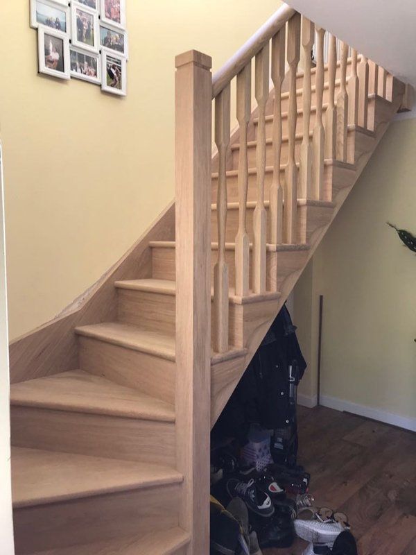 curved wooden staircase on white wall