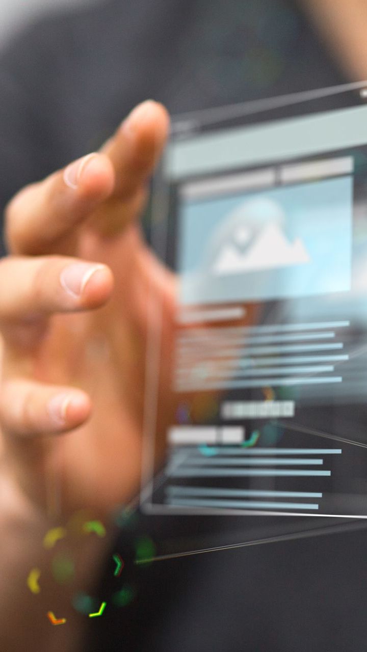 A man is holding a futuristic tablet in his hands.