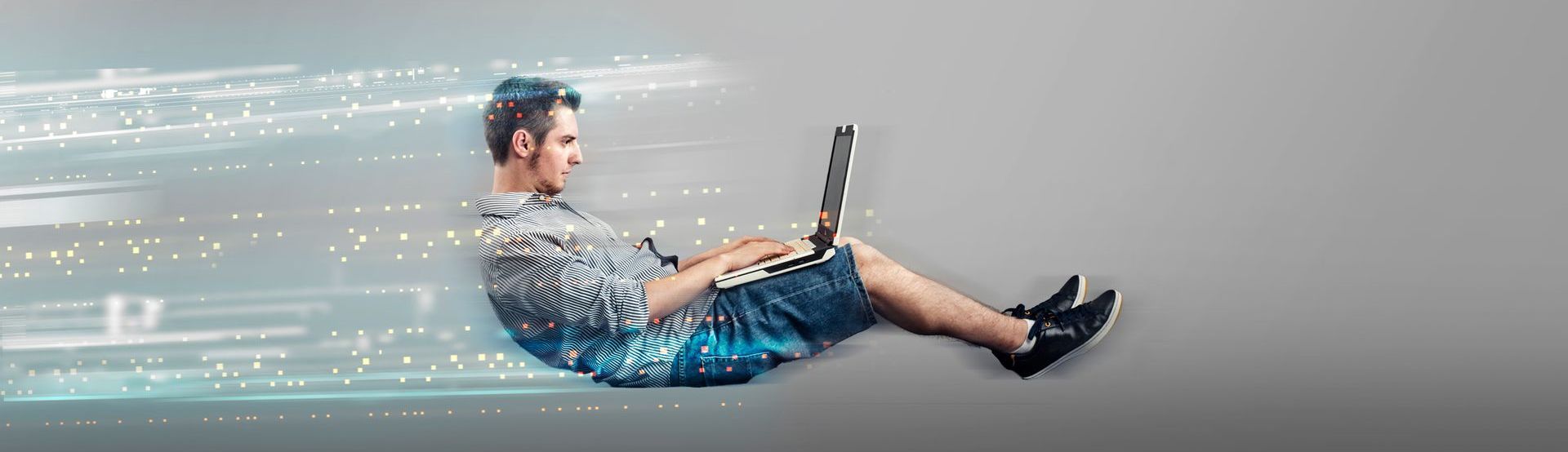 man floating in the air with laptop with speed pixels behind him