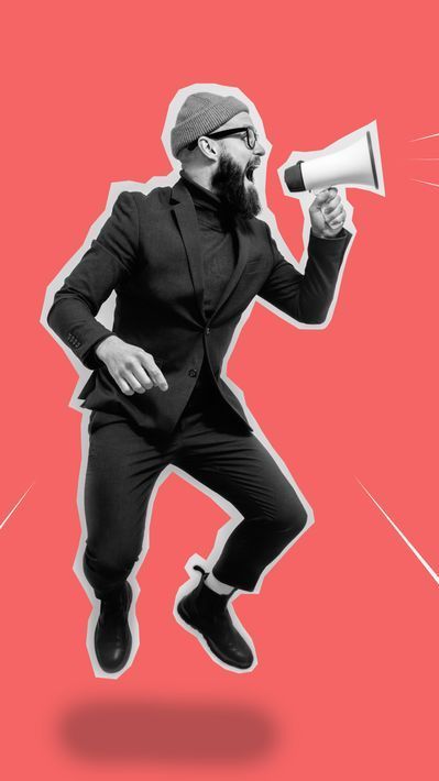 A man in a suit is jumping in the air while holding a megaphone.
