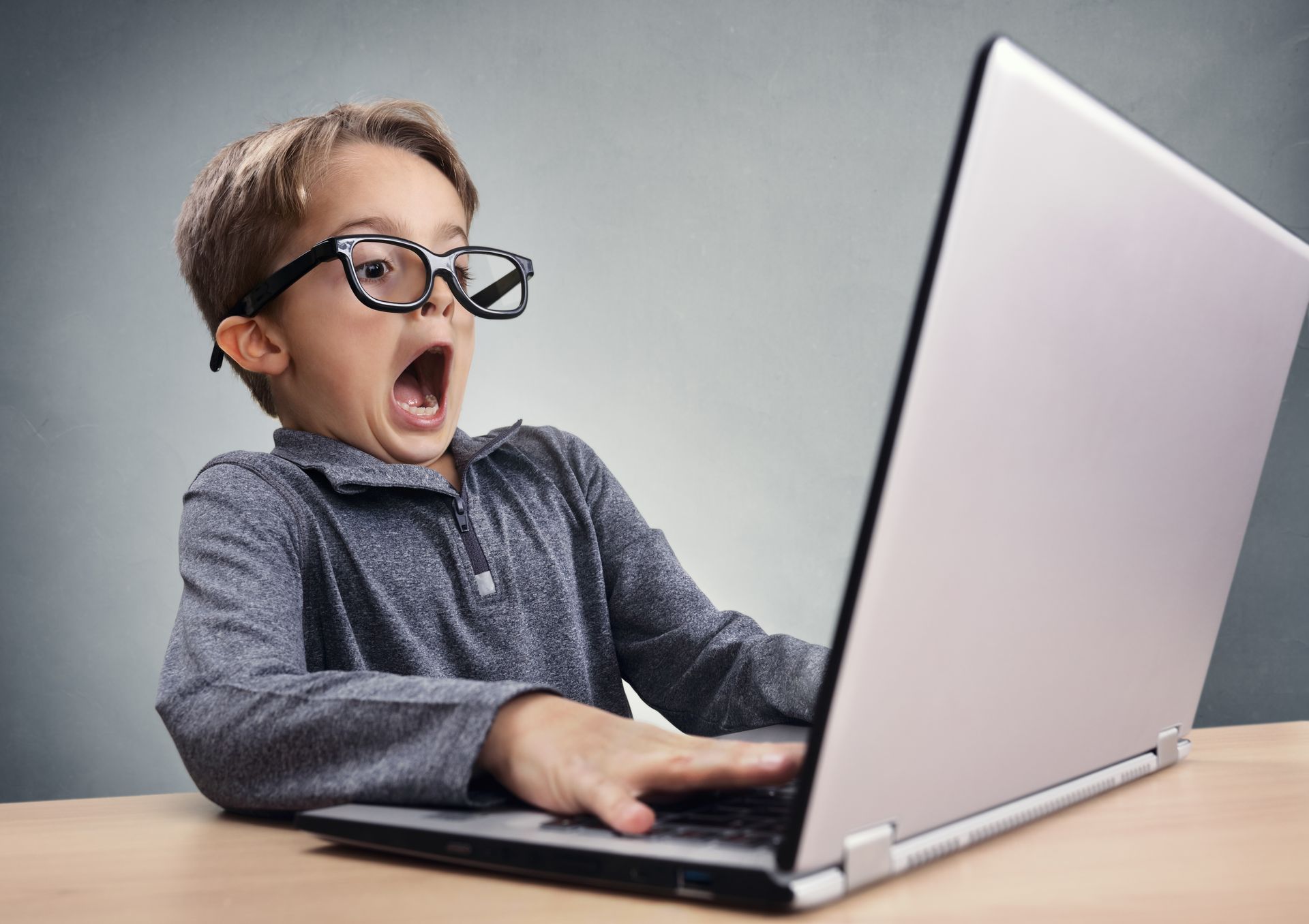 Young boy staring in panic at computer screen