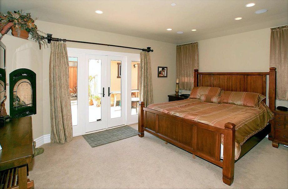 A bedroom with a large bed and sliding glass doors
