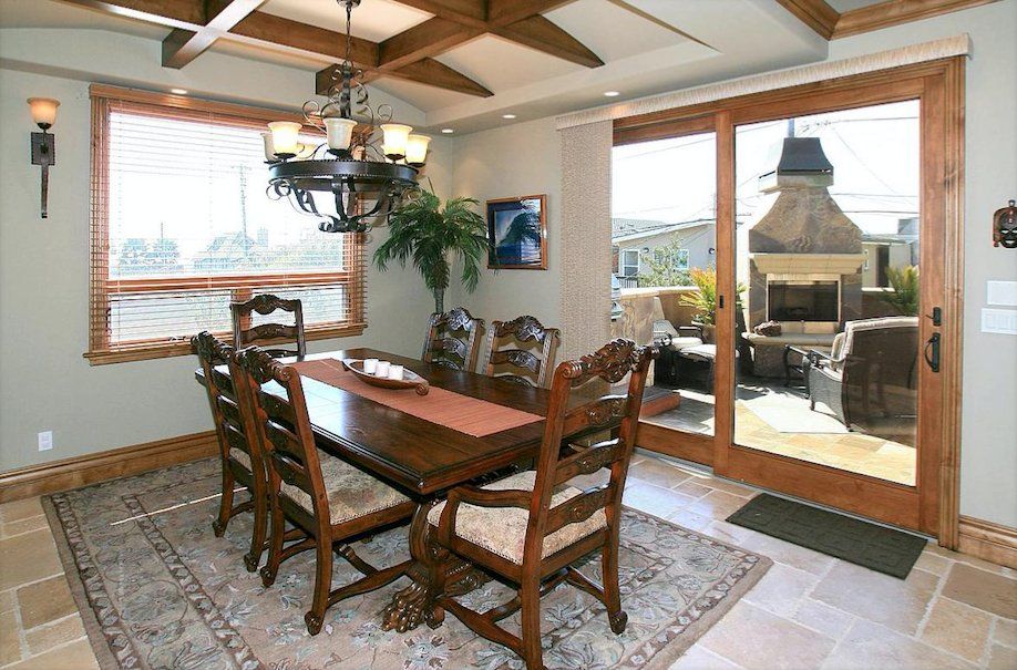 A dining room with a table and chairs and sliding glass doors
