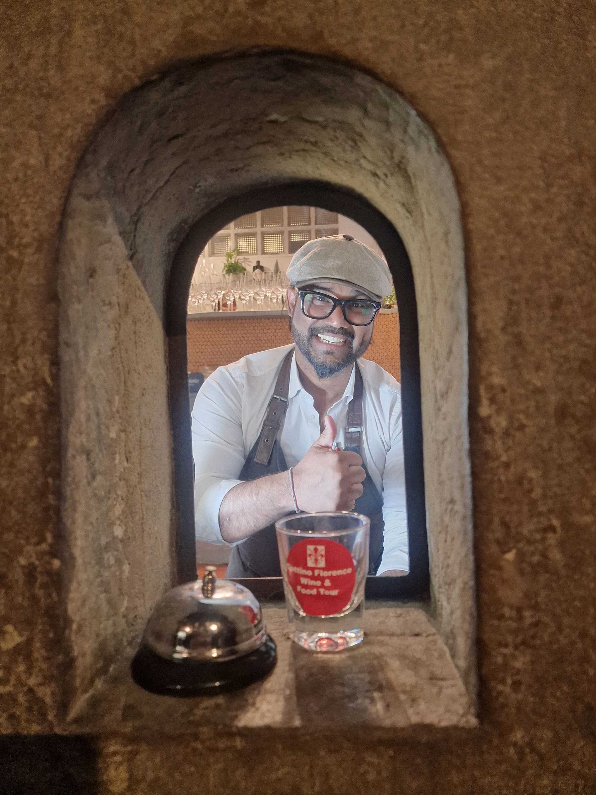 Worker serving wine at a wine window in Florence.