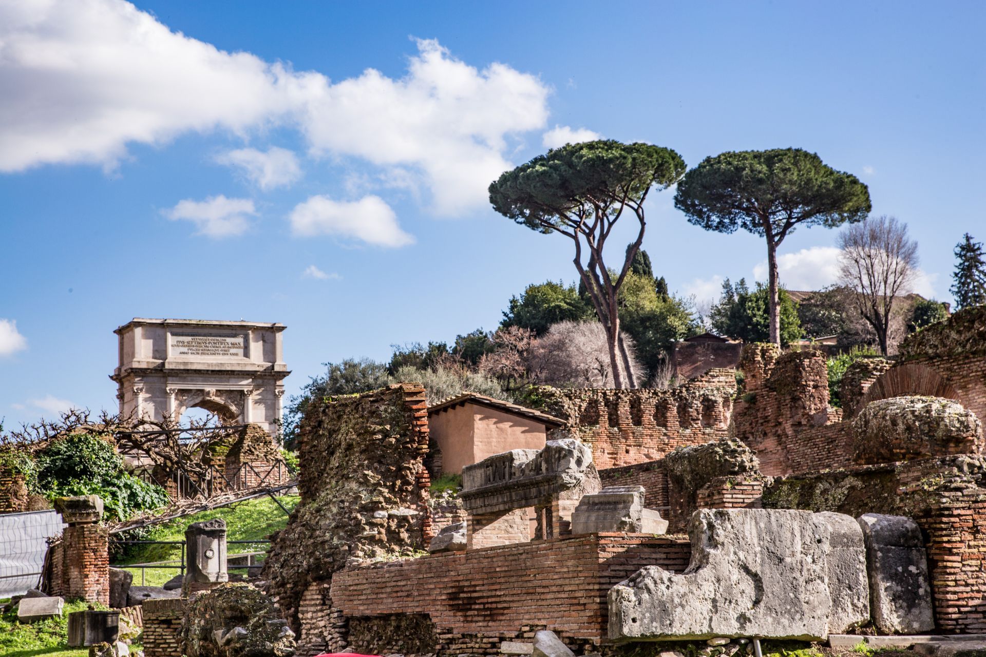 Ancient ruins and buildings in Rome under a clear blue sky.