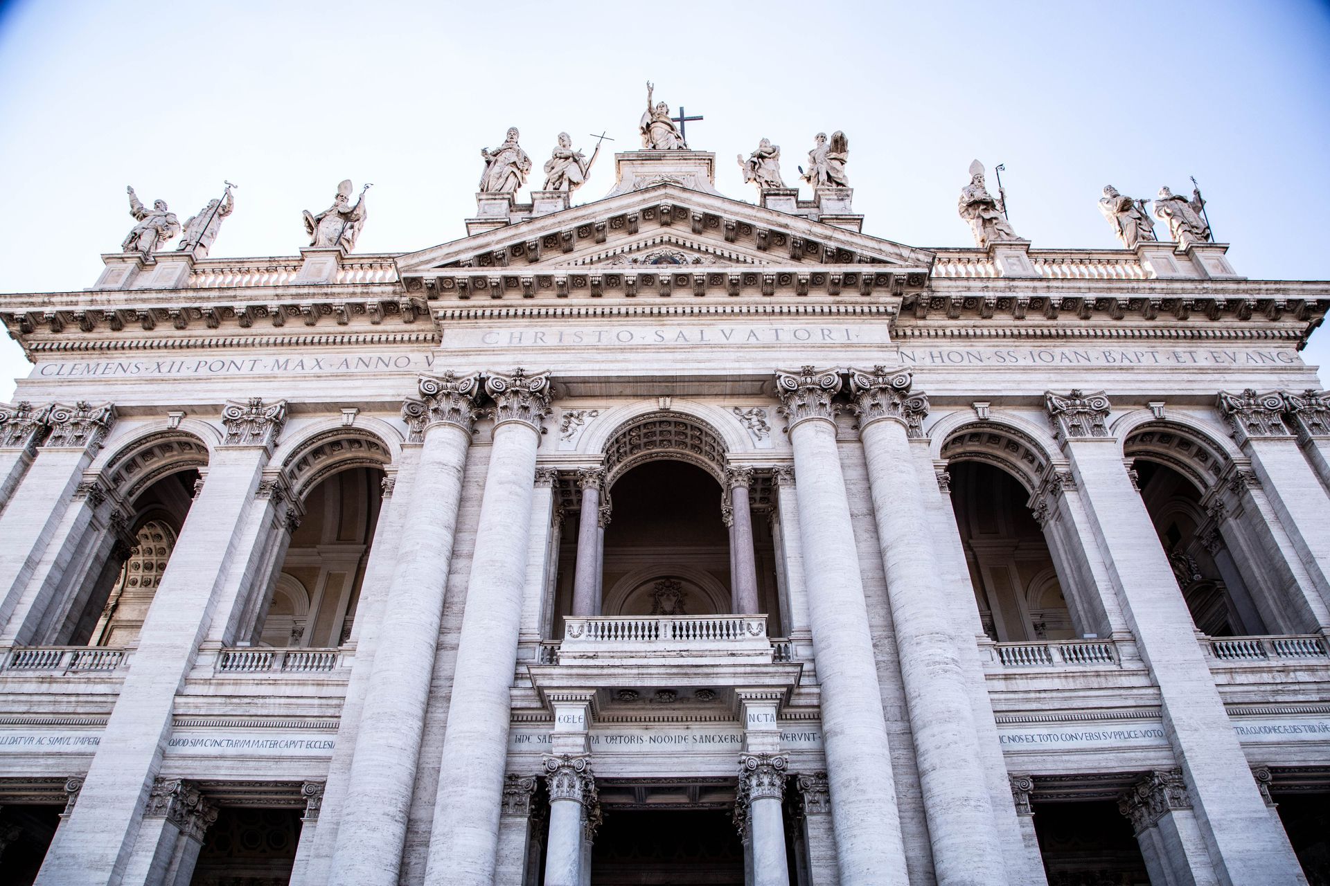 St. Peter's Basilica in Vatican City, seen from afar, with its iconic dome and framed by trees.