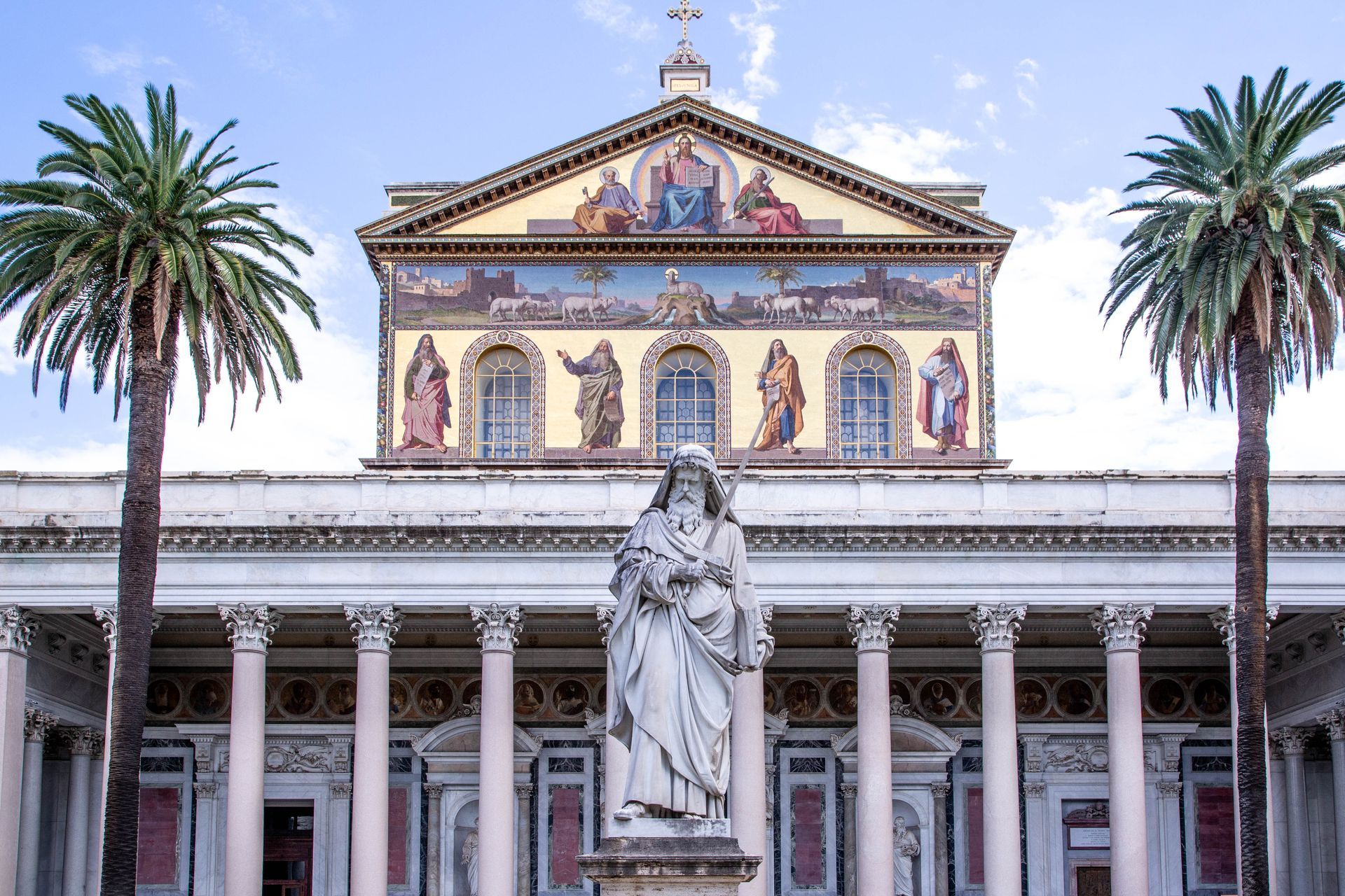 St. Peter's Basilica in Vatican City, seen from afar, with its iconic dome and framed by trees.