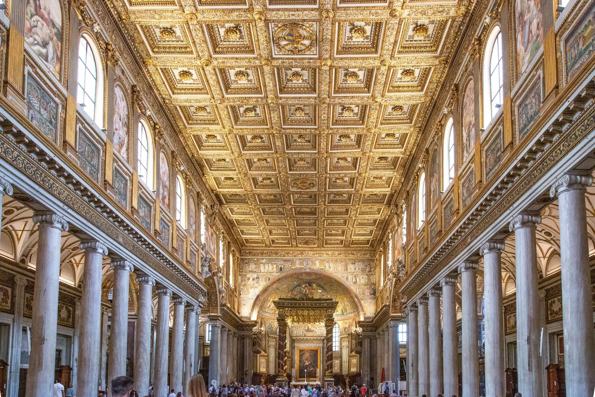 St. Peter's Basilica in Vatican City, seen from afar, with its iconic dome and framed by trees.